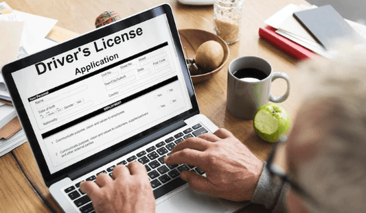 Person filling out an online driver's license application on a laptop at a desk, Pogo Cycles e-bike context